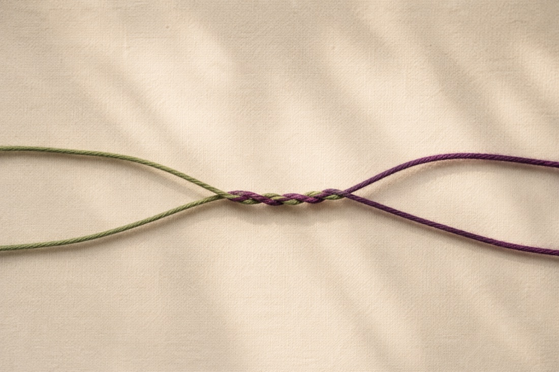 Two threads (one sage green, one aubergine) weaving together into a single strand